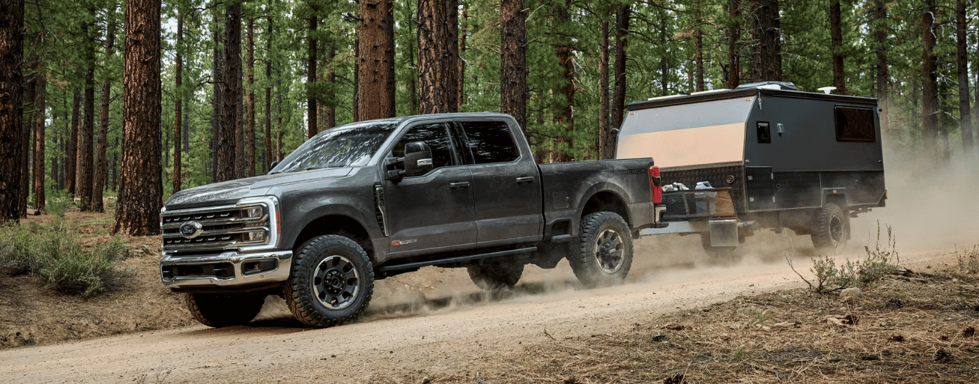 Grey 2026 Ford F-250 SD Tremor towing a camper off-road